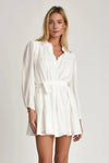 Woman wearing Pheby white dress with belt on a plain background