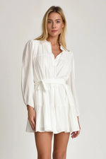Woman wearing Pheby white dress with belt on a plain background