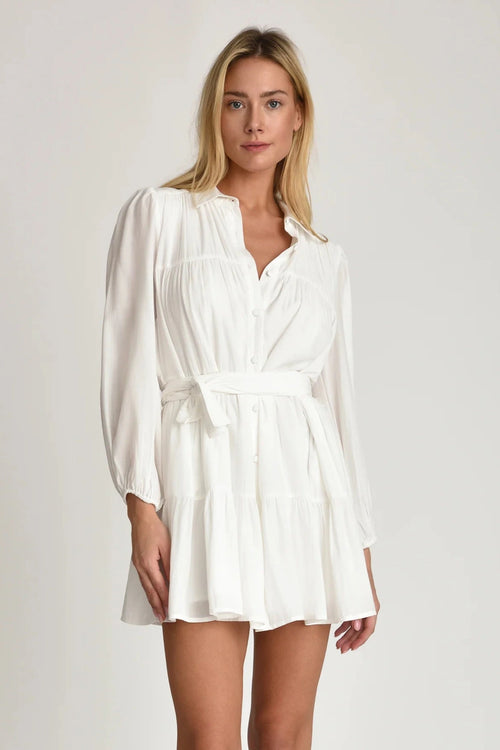Woman wearing Pheby white dress with belt on a plain background