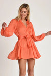 Woman wearing coral coloured Pheby dress on a white background