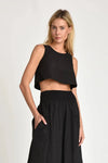 Woman wearing a black Nini sleeveless top and black Nini maxi skirt on a white background