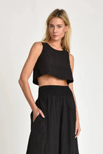Woman wearing a black Nini sleeveless top and black Nini maxi skirt on a white background