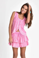 Woman wearing coquette pink skirt on a white background