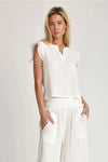 Woman wearing Evy white top on a plain background