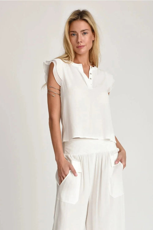 Woman wearing Evy white top on a plain background