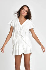 Woman wearing white Hailey top with a plain background