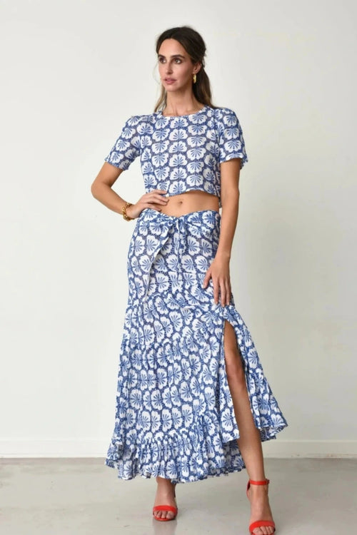 Woman wearing Julie blue patterned outfit with a white background